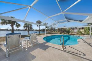 una piscina con dos sillas y una sombrilla en Five Palms, en Sanibel