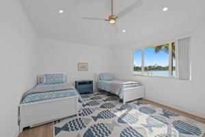 Un dormitorio con una cama y una silla y una ventana. en Five Palms, en Sanibel 44 fotos más