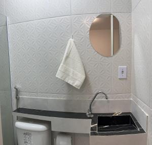 a bathroom with a sink and a mirror and a toilet at Studio privativo com Ar condicionado in Lauro de Freitas