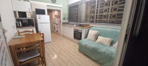 a kitchen with a couch and a table in a room at Vos vacances à la mer in Valras-Plage