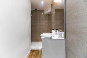 a bathroom with a sink and a shower at Résidence Gilbert - Appartements design centre ville in Vichy +80 photos