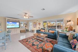 ein Wohnzimmer mit blauen Sofas und einem Tisch in der Unterkunft Peace, Love & Shells in Sanibel