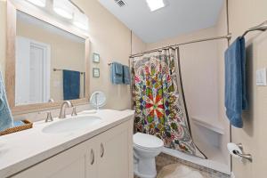 ein Badezimmer mit Waschbecken, Toilette und Duschvorhang in der Unterkunft Peace, Love & Shells in Sanibel + 33 Fotos
