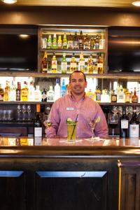 a man standing behind a bar with two martini glasses at Lodges at Deer Valley in Park City