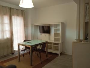 a living room with a table and a tv at La Casona de Betanzos in Betanzos