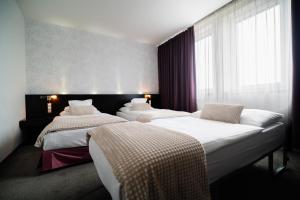 A bed or beds in a room at Hotel Turiec