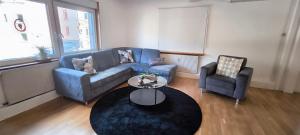 a living room with a blue couch and two chairs at 70 qm Ferienwohnung, in Groß-Bieberau