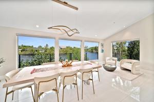 Un comedor con una gran mesa blanca y sillas. en Greek Villa Isle, en Sanibel
