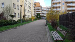 Una calle vacía con un banco y algunos edificios. en Radzikowskiego 100B, en Cracovia