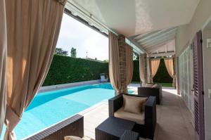 a swimming pool with two chairs and a couch next to at Villa Giuly in Sirmione