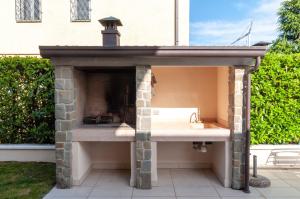 a outdoor kitchen with a fireplace in a backyard at Villa Giuly in Sirmione