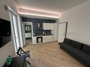 een woonkamer met een zwarte bank en een keuken bij Casa Bavosa via Cacciatore in Salerno