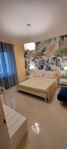 una camera con due letti e una parete floreale di Raggio di Sole a Gaeta