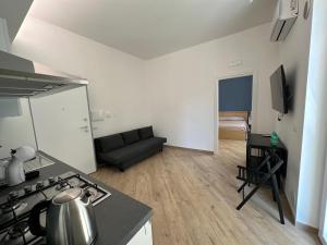 een keuken en een woonkamer met een fornuis en een bank bij Casa Bavosa via Cacciatore in Salerno