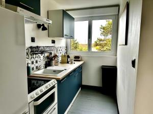 カイユー・シュル・メールにあるLe cabestan en Baie de Somme 700m de la plage phoquesの青いキャビネットと窓付きの小さなキッチン +13枚の写真