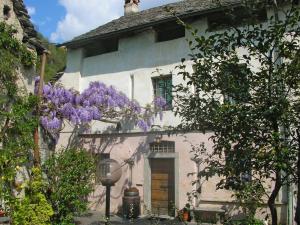 a white house with purple flowers on the side of it at Al Ciod d'Or by HolAp SA in Tegna