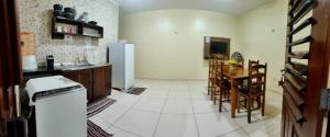 a kitchen with a refrigerator and a table and chairs at Chalés Estrelas Do Mar in Barra Nova