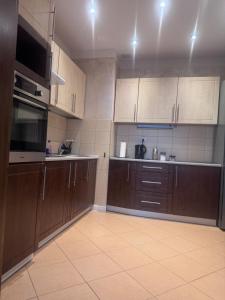 une cuisine vide avec des armoires marron et un évier dans l'établissement Kamienica Apartament Iława PIERWSZE PIĘTRO, à Iława