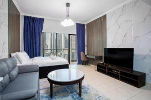 a living room with a couch and a tv at Burj Al Nujoom Luxurious Apartment Downtown Dubai Mall in Dubai