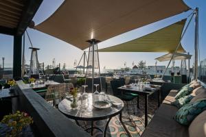 a restaurant with tables and chairs and a view of a harbor at Le Palazzo in Essaouira