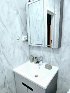 a white bathroom with a sink and a mirror at Golden house deluxe in Bukhara