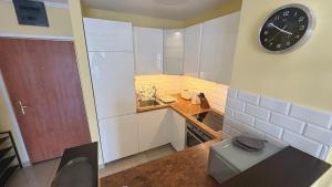 a small kitchen with a clock on the wall at Dandár Family Residence Free Parking in Budapest +22 photos