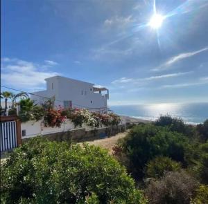 a building on a hill with the ocean in the background at Blue ocean villa in Asilah