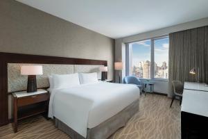 a bedroom with a large bed and a large window at InterContinental New York Times Square by IHG in New York