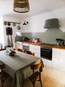 a kitchen with a table with chairs and a stove at Maison de caractère 170m2 coeur de village in Saint-Montan