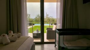 a bedroom with a bed and a view of a patio at Three Charites Resort in Gialova +82 photos