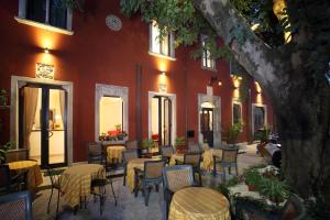a patio with tables and chairs in front of a building at Villa Astoria in Taormina