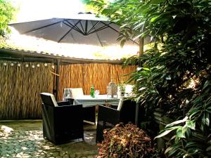 a patio with a table and an umbrella at Ferienwohnung am Ellerbach in Hessisch Oldendorf +77 photos