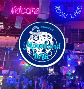 een neonbord in een bar met dansende mensen bij Moonland Bar and Hostel in Haad Rin