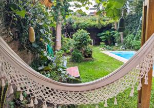 a hammock in a garden with a pool at House - Organic Vegetable Garden and Swimming Pool in San Isidro