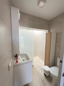 Un baño con un lavabo blanco y un inodoro. en La casa de la playa, en Playa Quemada