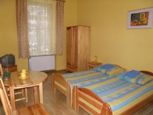 - une chambre avec un lit et une table en bois dans l'établissement Art-Mont, à Cracovie