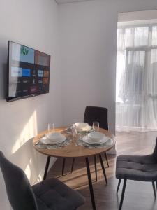 una sala da pranzo con un tavolo con sedie e una tv di Жилой комплекс Apartex Burabay, улица Уалиханова 7А a Shchuchinsk Altre 22 foto