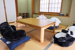 松本市にあるVacation Rental NAGISAのテーブルの周りにぬいぐるみが座っている部屋 +83枚の写真