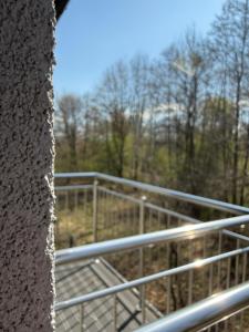 a view of a metal fence with trees in the background at Noclegi Laguna in Żywiec +59 photos