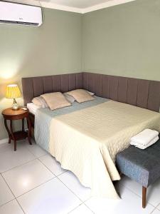 ラウロ・ジ・フレイタスにあるCharmoso Village Praianoのベッドルーム(ベッド1台、テーブル、ランプ付)