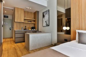 a bedroom with a bed and a desk and a kitchen at Regent Resort Budva in Budva