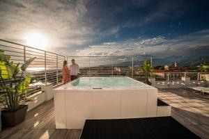 two people standing on a balcony with a hot tub at Hotel Esplanade in Marina di Pietrasanta