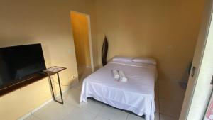 a small room with a white table and a tv at Pousada 4 Elementos Guaruja in Guarujá