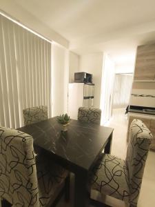 eine Küche mit Tisch und Stühlen und einem Kühlschrank in der Unterkunft Edificio Eclipse in Ushuaia