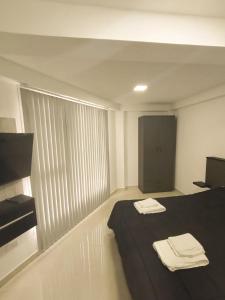 ein Zimmer mit einem Bett mit zwei Handtüchern darauf in der Unterkunft Edificio Eclipse in Ushuaia