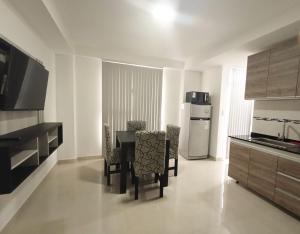 eine Küche mit Tisch und Stühlen und einem Kühlschrank in der Unterkunft Edificio Eclipse in Ushuaia