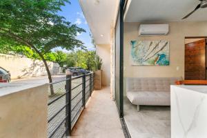 un balcone con un divano e una recinzione di 2-BR Aldea Zama Sanctuary of Tulum a Tulum Altre 28 foto