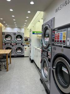 a laundry room with three washing machines and a table at 池袋アンプリルHouse3F Cozy for 1-3 guests in Tokyo