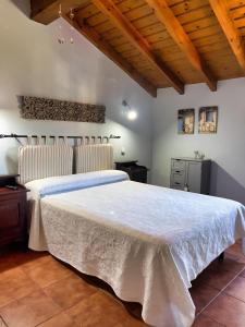 a bedroom with a large white bed with a wooden ceiling at Apartamentos Las Casucas de Gema in Isla
