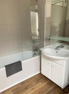ein weißes Badezimmer mit Waschbecken und Dusche in der Unterkunft Appartement La Foncière in Saint-Lary-Soulan